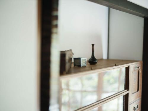 a wooden cabinet with a vase sitting on top of it at 里の宿 門後藤 in Taketa
