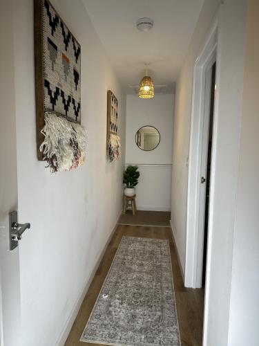 a hallway with white walls and a rug on the floor at Rosern Short Stays in St. Ives