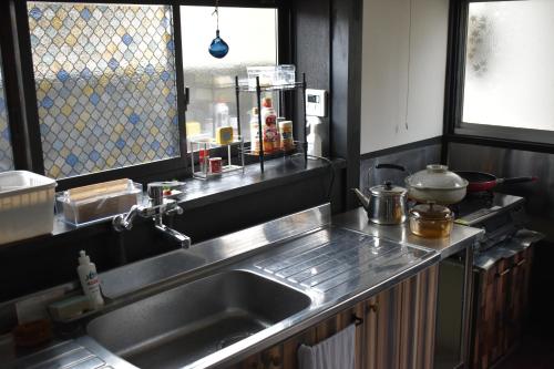 a kitchen with a stainless steel sink and a window at Zaō Hütte 一棟貸し in Zao
