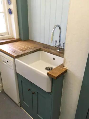 a kitchen with a sink and a counter top at Cosy Cottage with Large Garden I Semi Rural Retreat! Nearby Countryside, Beaches & Goodwood - Chichester Holiday Properties in Eartham