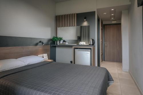 a bedroom with a bed and a small kitchen at Elizabeth Queen Luxury Rooms in Paralia Katerinis