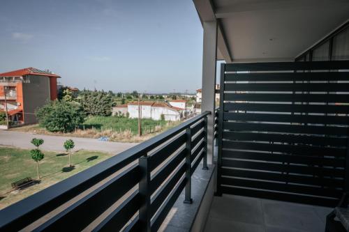 a balcony with a fence and a view of a street at Elizabeth Queen Luxury Rooms in Paralia Katerinis