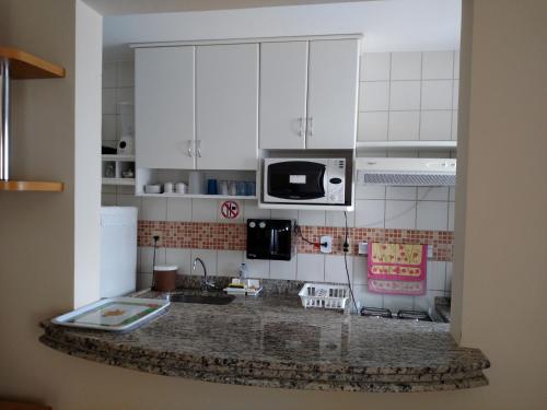 a kitchen with white cabinets and a counter top at Prive das Thermas - 301B in Caldas Novas