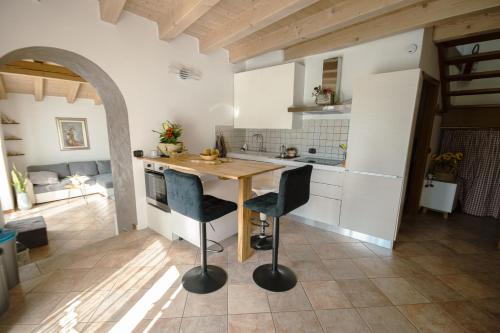 a kitchen with a wooden table and two chairs at Casa Al Castagneto in Ceniga