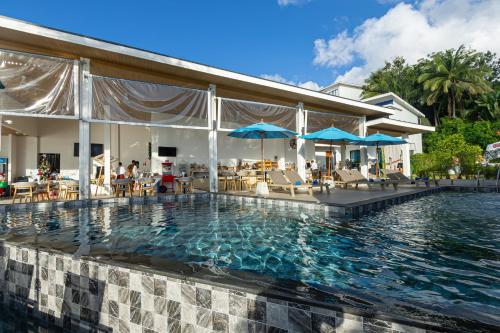 a pool at a resort with chairs and umbrellas at Three Trees Samui Resort - Sarocha Villa in Lamai