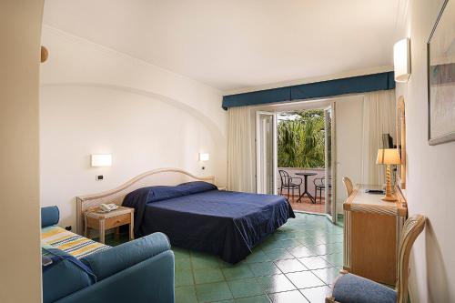 a bedroom with a bed and a couch and a table at Hotel Floridiana Terme in Ischia Town