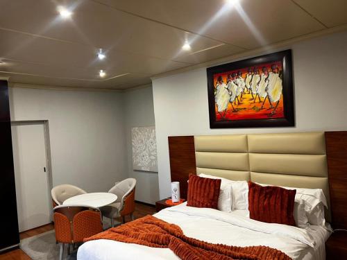 a bedroom with a bed and a painting on the wall at Emangweni Guest House in Vryheid