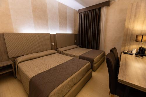a hotel room with two beds and a table at Hotel Gialletti in Orvieto