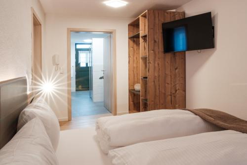 a bedroom with a bed and a tv on the wall at Ferienwohnung Beim Paschamarte in Schwangau
