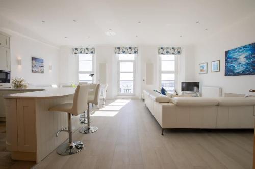 a white living room with a couch and a table at Breathtaking Views at The Bay in Torquay