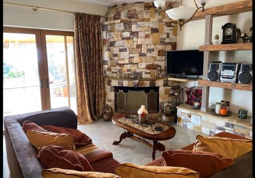 a living room with a couch and a fireplace at Stone Horizon Villa in Eretria