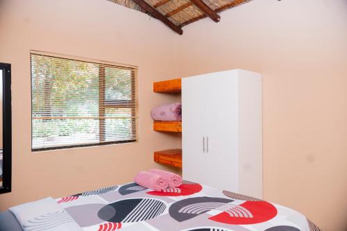 a bedroom with a bed with a pink stuffed animal on it at Falcon Lodge (ET) in Bela-Bela