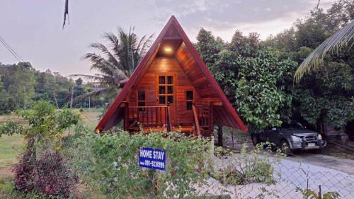 a small wooden house with a sign in front of it at Meesaeng Homestay in Thalang
