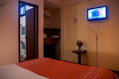a bedroom with a bed and a tv on the wall at Hotel e Pousada La Dolce Vita in Canoa Quebrada