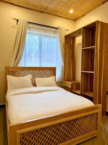 a bedroom with a large bed in front of a window at JND Cozy Homes in Iringa