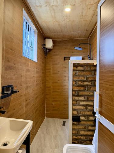 a bathroom with a toilet and a sink and a window at JND Cozy Homes in Iringa