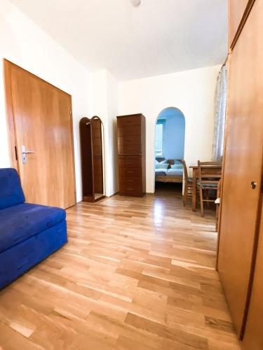 a living room with a blue couch and a wooden floor at Gästehaus am Main in Randersacker
