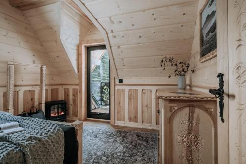 a log cabin bedroom with a fireplace and a bed at Tatrowisko Zakopane Domki Góralskie in Zakopane