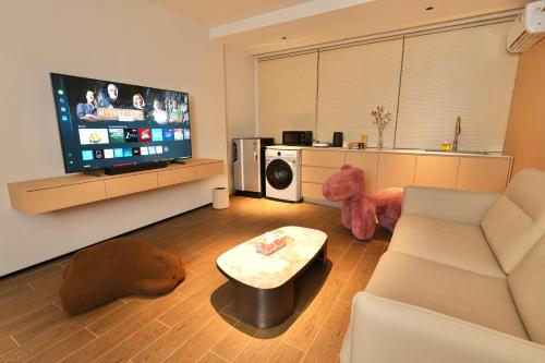 a living room with a white couch and a tv at Migoo Chiang Mai in Chiang Mai