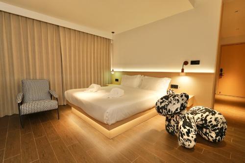 a bedroom with a bed and a teddy bear sitting on the floor at Migoo Chiang Mai in Chiang Mai