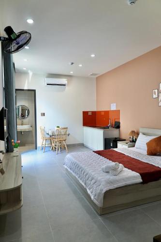 a bedroom with a large bed and a kitchen at Minimalhaven Stay in Vung Tau