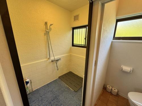 a small bathroom with a shower and a toilet at Sunny side story hotel 九十九里 in Kujukuri