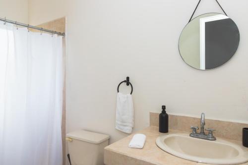 a bathroom with a sink and a mirror and a toilet at Outsite Los Cabos in San José del Cabo