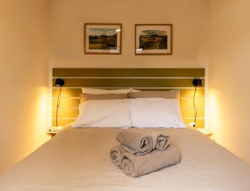 a bedroom with a bed with towels on it at Loom - Modern Lodge in the Woods in Putten