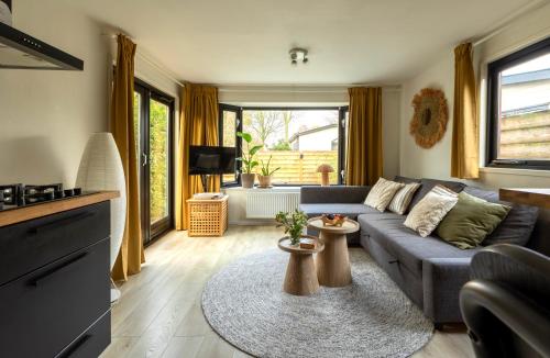 a living room with a couch and a table at Loom - Modern Lodge in the Woods in Putten