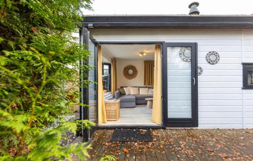 an open door of a house with a couch at Loom - Modern Lodge in the Woods in Putten