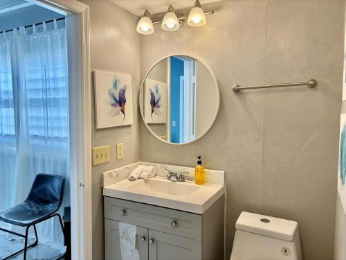 a bathroom with a sink and a mirror and a toilet at 6165 Carrier Drive Unit 1802 Building 1 in Orlando