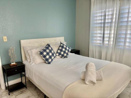 a bedroom with a white bed with pillows and a window at 6165 Carrier Drive Unit 1802 Building 1 in Orlando