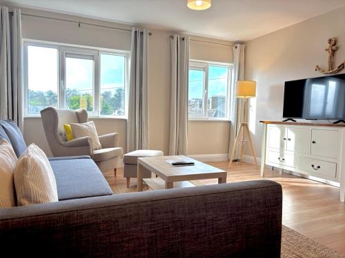 a living room with a couch and a tv at Cobh Coastline Hideaway in Cobh