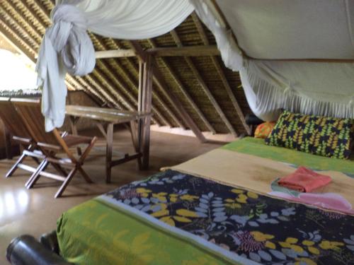 a bedroom with two beds and a chair in a room at Topi inn in Padangbai