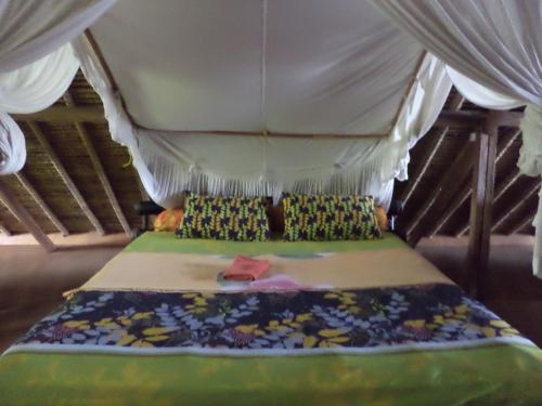 a bed with a canopy in a room at Topi inn in Padangbai