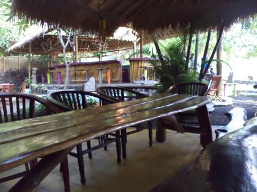 a wooden bench in a restaurant with tables and chairs at Topi inn in Padangbai