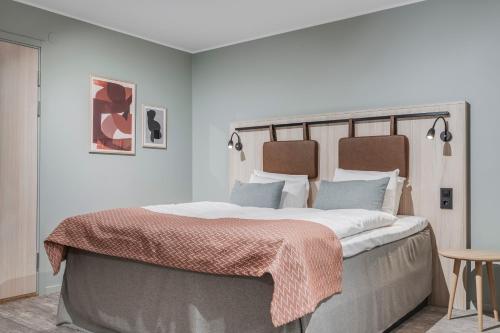 ein Schlafzimmer mit einem großen Bett, auf dem eine Decke liegt in der Unterkunft Quality Hotel Luleå in Luleå