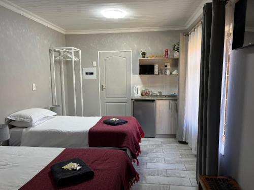 a hotel room with two beds and a kitchen at Lafenis Selfsorg in Jan Kempdorp