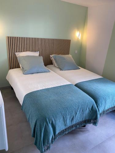 two beds sitting next to each other in a bedroom at Maison Les Cygnes face au lac in Changey