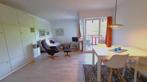 a kitchen and living room with a table and chairs at Terrassenhaus, FeWo 32 in Duhnen