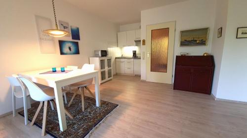 a kitchen and dining room with a white table and chairs at Terrassenhaus, FeWo 32 in Duhnen