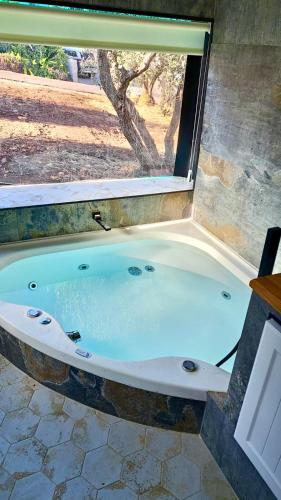 a bath tub in a room with a window at צימרבוס כנרת Galilee Bus in Migdal