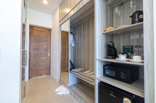 a walk in pantry with a microwave in a room at Three Trees Samui Resort - Sarocha Villa in Lamai