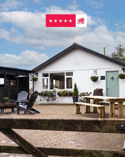 a house with a flag on top of it at 3-Country retreat with outdoor kitchen and pizza oven! in Pont Sticill