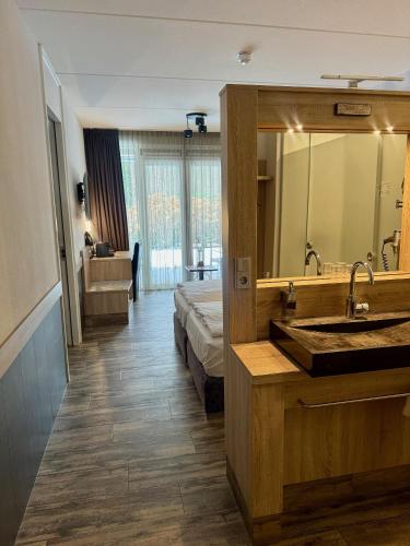 a bathroom with a bed and a sink and a mirror at Hotel Erve Hulsbeek in Oldenzaal