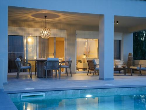 a patio with a table and chairs next to a pool at Villa Alaya in Kos