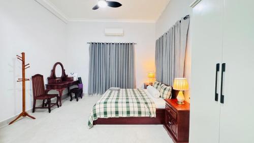 a bedroom with a bed and a desk and a piano at Spacious Siem Reap Sanctuary in Phumi Ta Phul