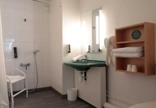 a bathroom with a green sink and a shower at B&B HOTEL Lourdes Centre Gare 3 étoiles in Lourdes