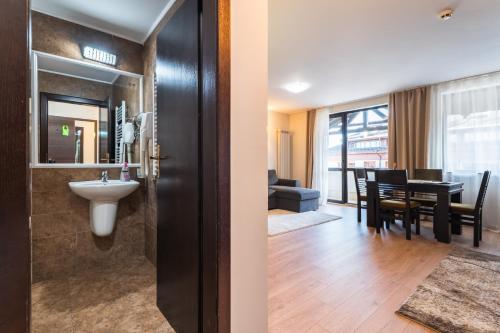 a bathroom with a sink and a dining room at Apart Hotel Dream in Bansko