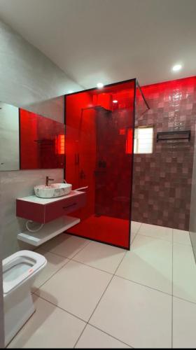 a red bathroom with a toilet and a shower at Teddy in Malpe